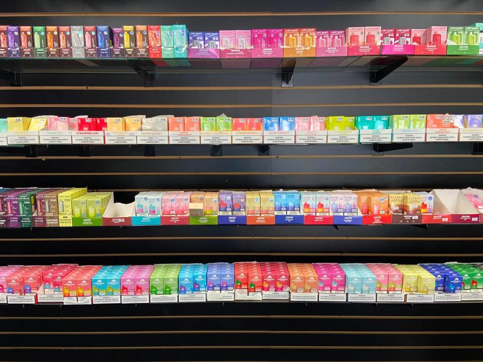 Rows of flavored tobacco vape juice, including varieties banned by Proposition 31, are displayed on the wall of a central Fresno smoke shop as seen on Oct. 18, 2023.