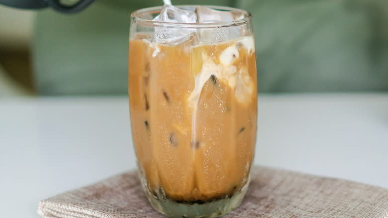 Pouring milk into an iced coffee