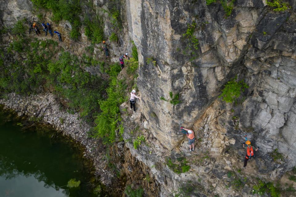 Climbers use cables and metal rungs to traverse the via ferrata rock wall at Quarry Trails Metro Park in Columbus on May 11. The 1,040-foot guided climb, believed to be the first urban via ferrata in the country, reaches heights of over 100 feet.