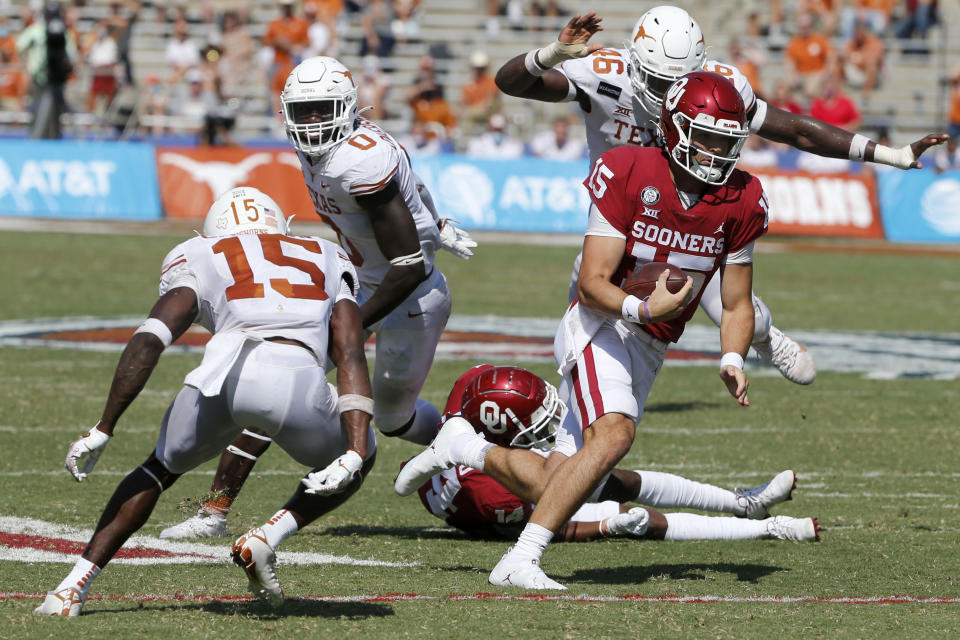 Oklahoma quarterback Tanner Mordecai (15) tries to get past Texas defensive back Chris Brown (15) during an NCAA college football game in Dallas, Saturday, Oct. 10, 2020. (AP Photo/Michael Ainsworth)