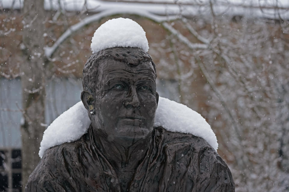 The statue of former Washington NCAA college football coach Jim Owens wears a coating of snow, Saturday, Feb. 13, 2021, in Seattle. Winter weather was expected to continue through the weekend in the region.(AP Photo/Ted S. Warren)