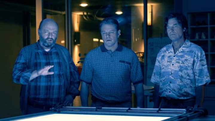 Three men stand in front of table in Air.