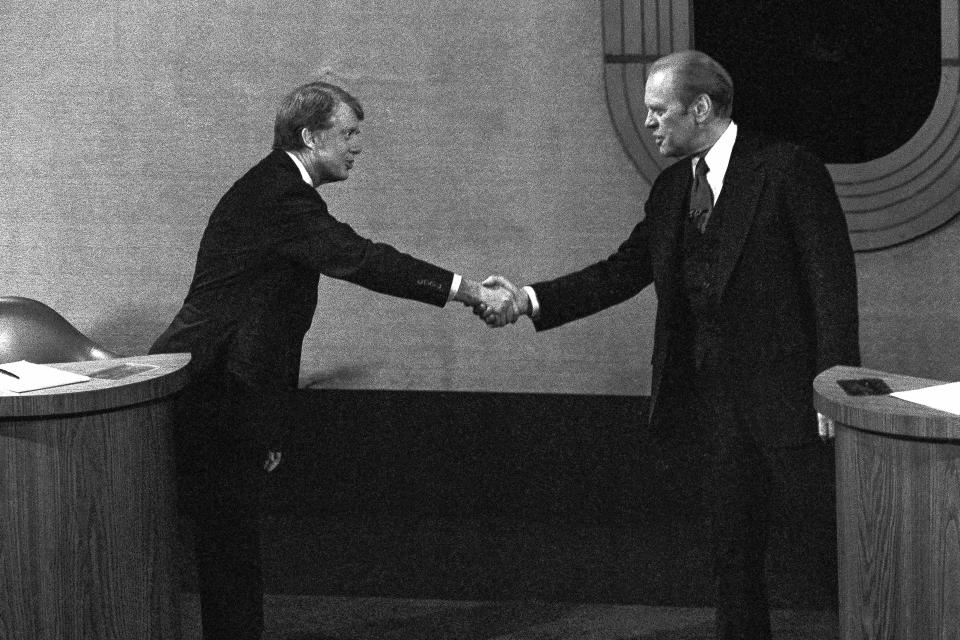 FILE - Jimmy Carter, left, and Gerald Ford, right, shake hands before the third presidential debate, Oct. 22, 1976, in Williamsburg, Va. (AP Photo/File)