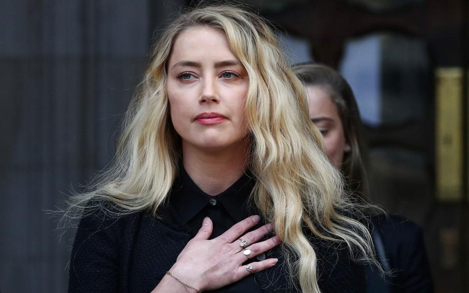 Amber Heard delivers a statement as she leaves the High Court in London - SIMON DAWSON/REUTERS