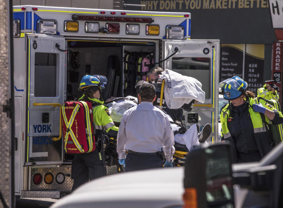 <p>A injured person is put into the back of an ambulance in Toronto after a van mounted a sidewalk crashing into a number of pedestrians on Monday, April 23, 2018. (Photo: Aaron Vincent Elkaim/Canadian Press) </p>