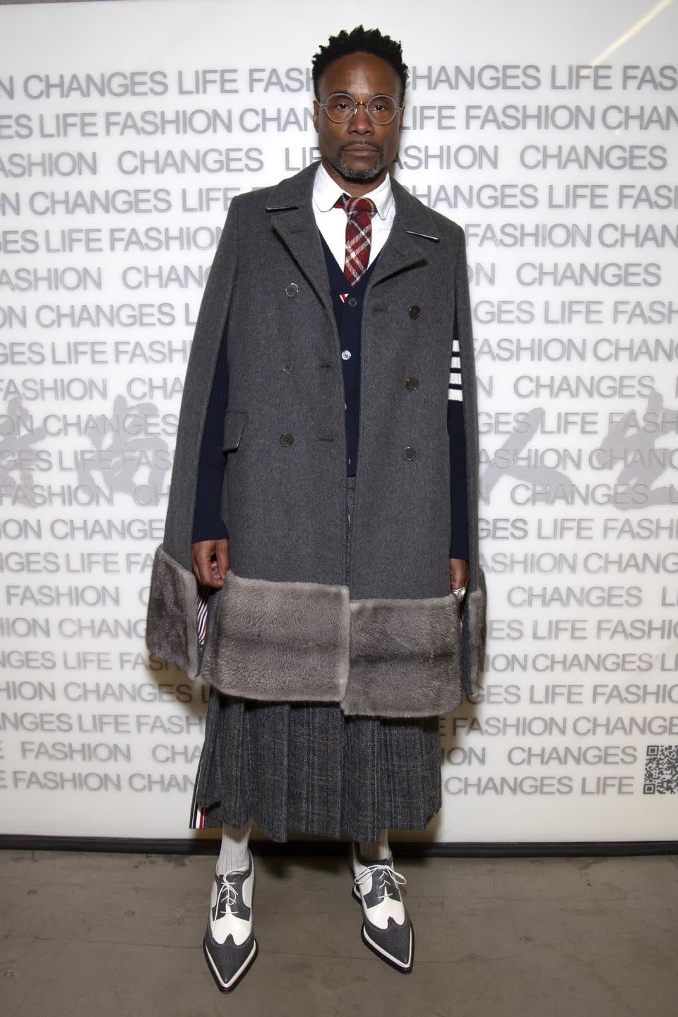 <p>The actor wore an all-grey school uniform-inspired look by Thom Browne to the Fashion Changes Lives event. The star styled the look with an oversize grey cape, navy blue cardigan, grey pleated skirt, grey and white lace-up brogues, white shirt and red tie. </p>