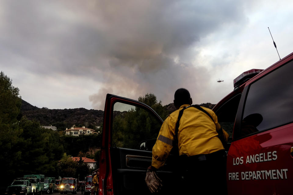 A Los Angeles Fire Department firefighter watches from his truck during a wildfire in the Pacific Palisades area of Los Angeles, Sunday, May 16, 2021. (AP Photo/Ringo H.W. Chiu)