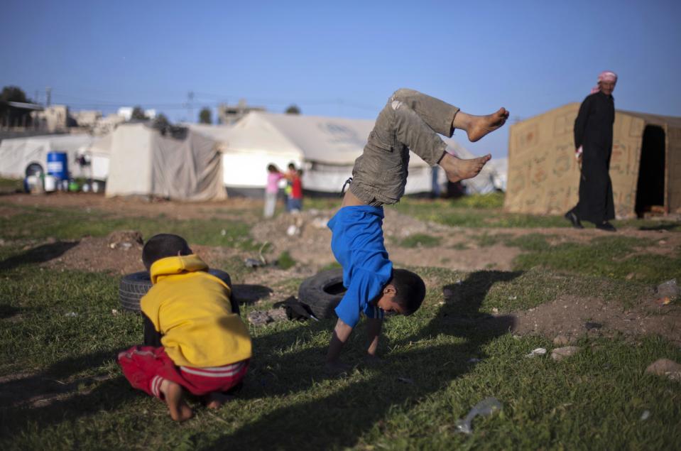 In this Friday, April 4, 2014 photo, Syrian boys play in an unofficial refugee camp on the outskirts of Amman, Jordan. Some residents, frustrated with Zaatari, the region's largest camp for Syrian refugees, set up new, informal camps on open lands, to escape tensions and get closer to possible job opportunities.(AP Photo/Khalil Hamra)