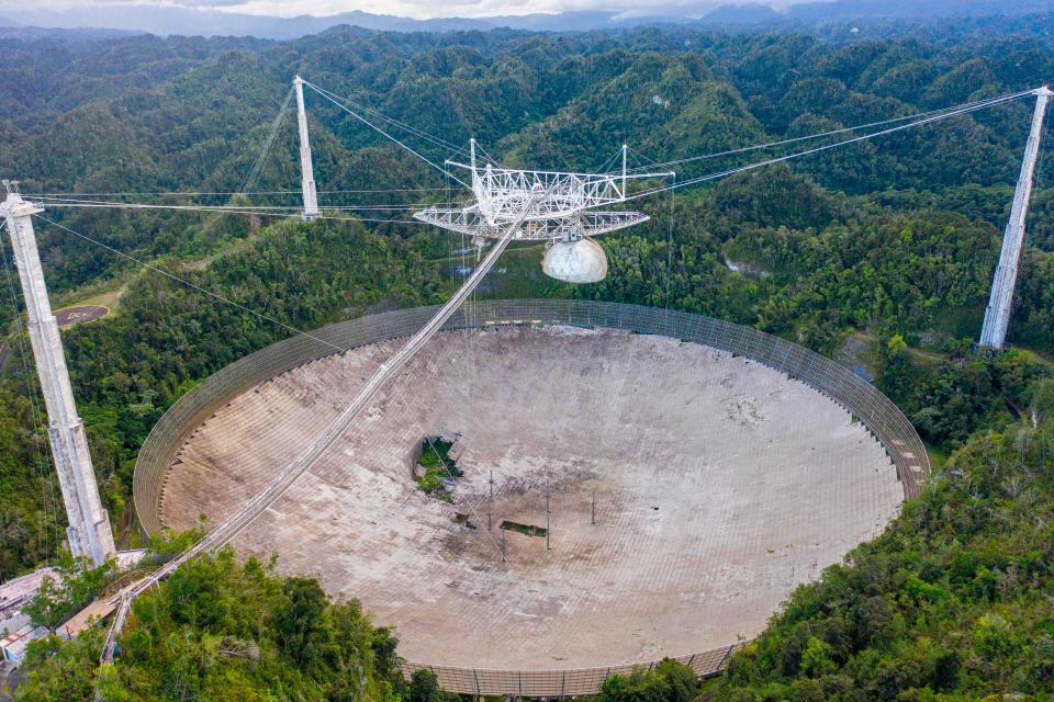 An aerial view shows a hole in the dish panels of the Arecibo Observatory in Arecibo, Puerto Rico, on November 19, 2020. The National Science Foundation announced it will decommission the radio telescope following two cable breaks in recent months which have brought the structure to near collapse.