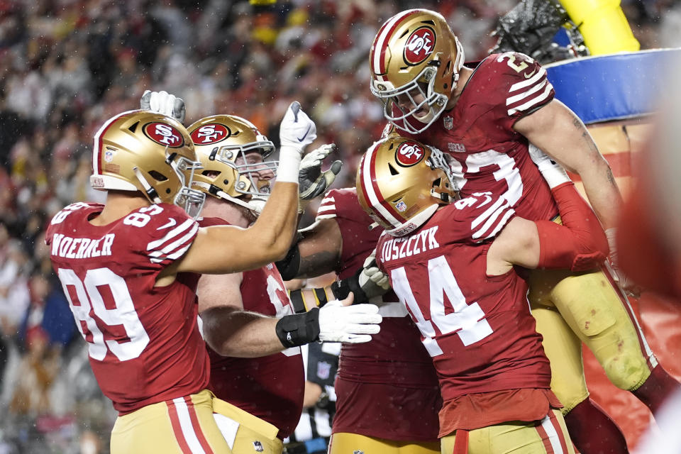 San Francisco 49ers running back Christian McCaffrey (23) celebrates his rushing touchdown with teammates during the second half of an NFL football NFC divisional playoff game against the Green Bay Packers Saturday, Jan. 20, 2024, in Santa Clara, Calif. (AP Photo/Ashley Landis)