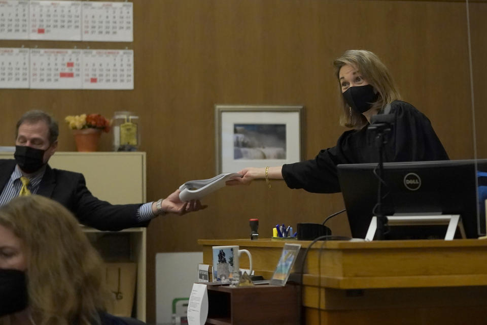 Judge Anne-Christine Massullo, right, hands paperwork to attorney Cliff Gardner, representing Scott Peterson, during a hearing at the San Mateo County Superior Court in Redwood City, Calif., Monday, Feb. 28, 2022. (AP Photo/Jeff Chiu, Pool)