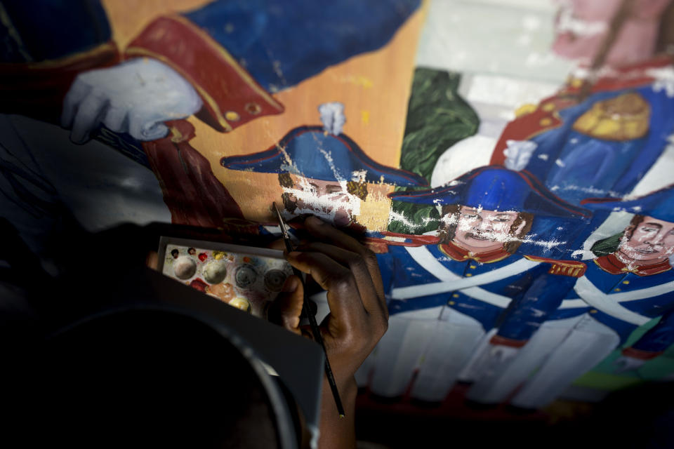 In this June 28, 2019 photo, Haitian artist Marc Gerard Estime works on the restoration of a painting by Haitian artist Edouard Duval Carrie, at the Musée d'Art du Collège Saint Pierre, in Port-au-Prince, Haiti. While life has begun anew for much of Haiti after the quake, the museum has been shuttered for nine years.It only recently opened a tiny room to display a handful of paintings. (AP Photo/Dieu Nalio Chery)