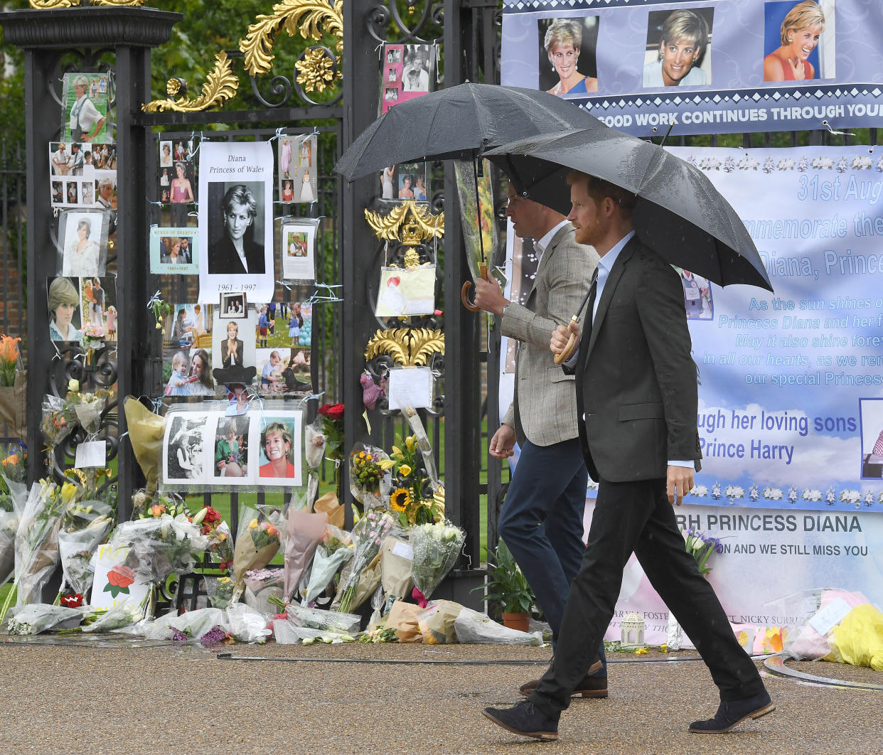 William and Harry look at tributes left by the public dedicated to their mother Princess Diana following their visit The White Garden, dedicated to the memory of Princess Diana, in Kensington Palace on Aug. 30, 2017.