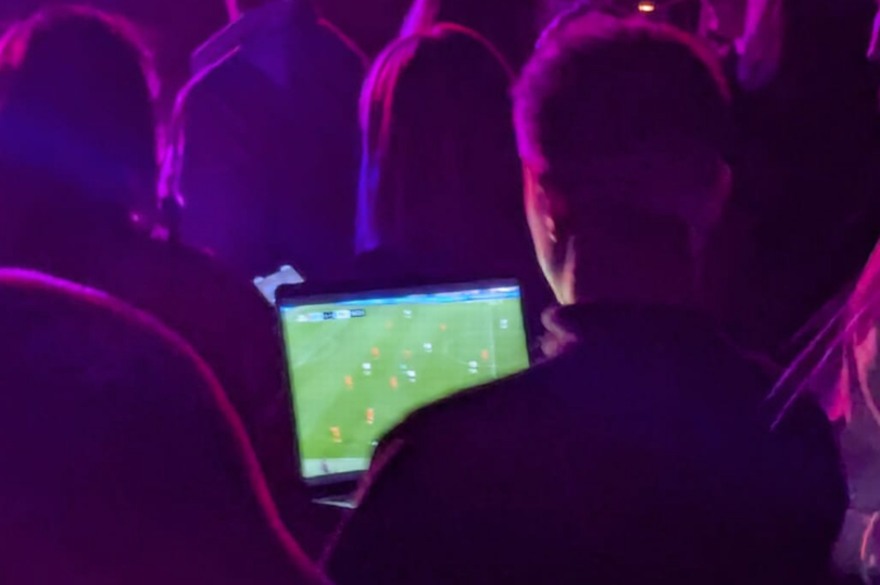 A fan watching England vs Netherlands during Kings of Leon concert