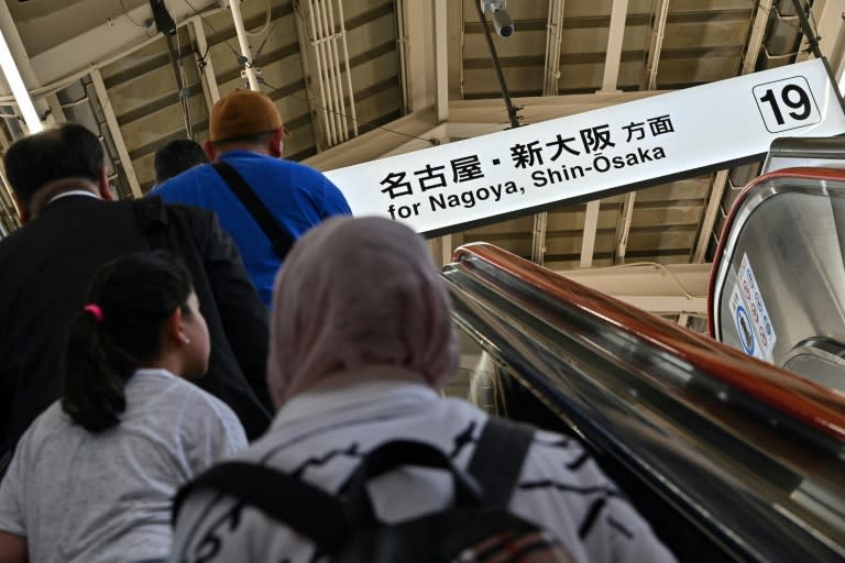 Unos pasajeros suben unas escaleras mecánicas hacia el andén de la estación del tren bala, o "shinkansen", desde y hacia Nagoya y Osaka en Tokio el 17 de abril de 2024 (Richard A. Brooks)