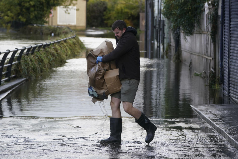 Michael Nugent, the owner of Nugelato ice cream cleans up his shop in Sugar Island, Newry Town, Northern Ireland, Wednesday, Nov. 1, 2023, amid heavy rainfall. France, England and countries across western Europe are bracing for what meteorologists warn could be some of the highest wind speeds the region has witnessed in decades as Storm Ciarán hurtles toward coastlines and is set to make landfall on Wednesday evening. (Brian Lawless/PA via AP)