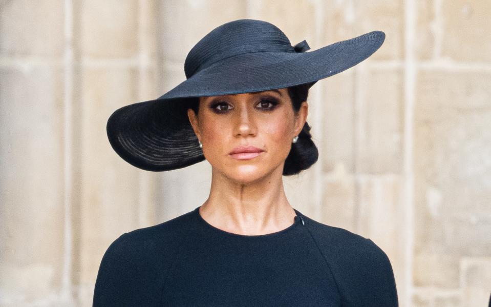 Meghan Markle wears a black dress and a black hat at Queen Elizabeth's funeral.