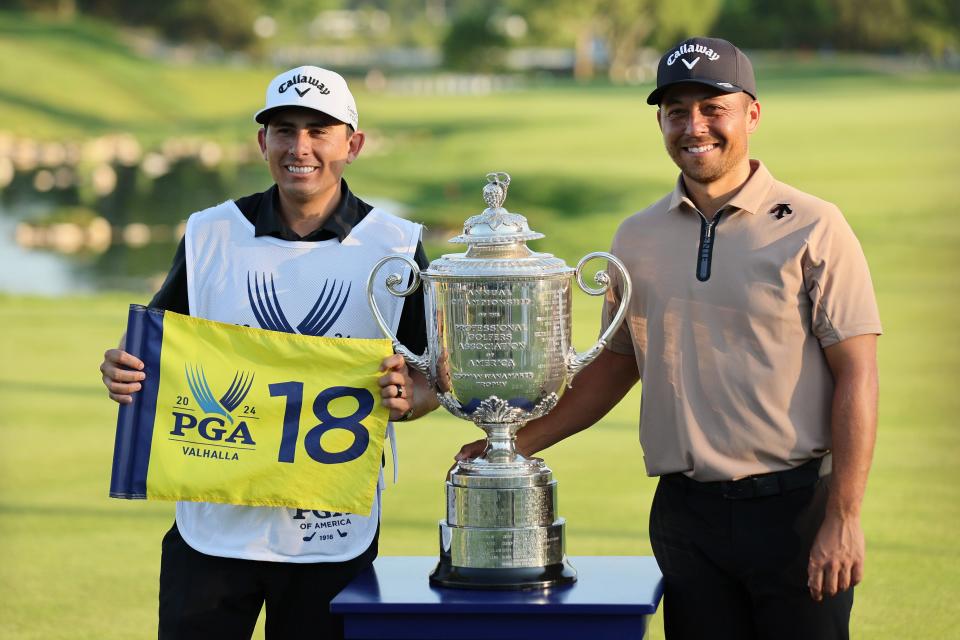 Xander Schauffele, right, and his caddie, Austin Kaiser, pose with the Wanamaker Trophy after winning the 2024 PGA Championship.