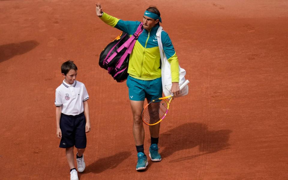 A boy accompanies Spain's Rafael Nadal as he enter center court  - AP