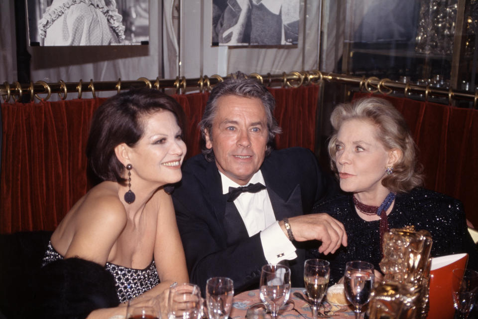 <p>Italian actress Claudia Cardinale, French actor Alain Delon and American actress Lauren Bacall at the Fouquet's restaurant, after the 1996 Cesar Awards ceremony. (Photo by Jean-François Rault/Sygma via Getty Images)</p>
