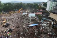 Rescue workers search for survivors in the rubble of a collapsed five-storey apartment building in Mahad. (Photo by PUNIT PARANJPE/AFP via Getty Images)