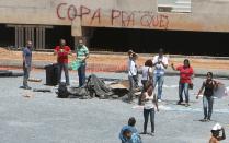 Demonstrators who managed to evade security and enter the Arena Pantanal stadium during a visit by FIFA Secretary General Jerome Valcke, protest against the public spending for the 2014 World Cup, in Cuiaba, October 8, 2013. Earlier this year, millions of Brazilians took to the streets to protest against the billions of dollars being invested into staging the 2014 soccer World Cup then the Olympics instead of health, education, public transportation, and security. The graffiti on the perimeter reads, "Cup for who?" REUTERS/Jose Medeiros (BRAZIL - Tags: SPORT SOCCER CIVIL UNREST POLITICS)