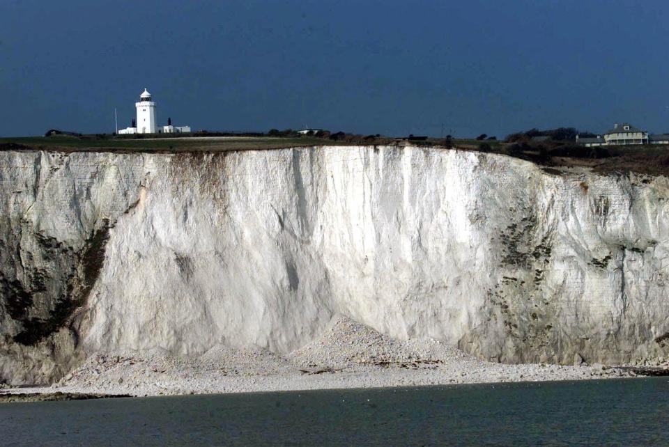 FILE - This is a Thursday, Feb. 1, 2001. file photo shows the lighthouse on top of the White Cliffs of Dover, England, after a large segment of chalk fell from the cliff after a landslide. Philosopher Julian Baggini has a high-altitude new assignment pondering the significance and symbolism of the White Cliffs of Dover. The National Trust, guardian of the landmarks on England's south cast, has appointed Baggini the cliffs' first writer in residence. Starting Monday, Aug. 20, 2012 he will spend a week living in a cliff-top lighthouse. Baggini said he hoped to learn “what the white cliffs of Dover mean for British people, including those for whom the cliffs were the first sight of the country which would become their adopted home." (AP Photo/Dave Caulkin, File)