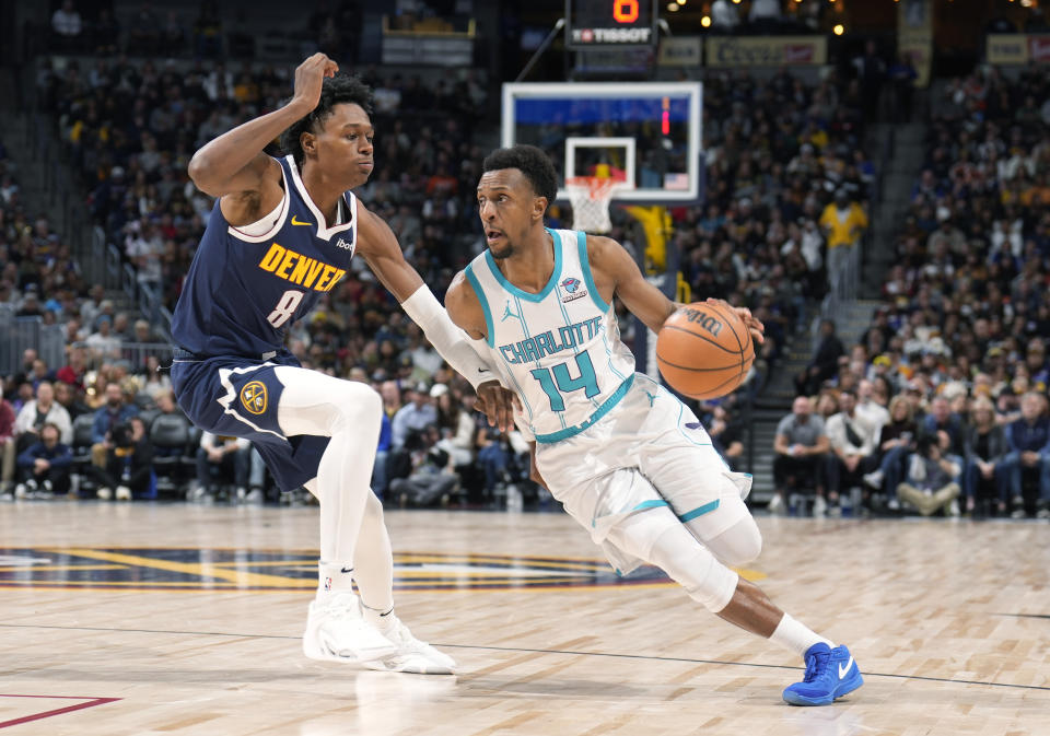 Charlotte Hornets guard Ish Smith (14) drives past Denver Nuggets forward Peyton Watson (8) in the second half of an NBA basketball game Monday, Jan. 1, 2024, in Denver. (AP Photo/David Zalubowski)