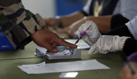 A Malaysian voter gets his finger marked with ink before he casts his ballot during the early voting for the general elections in Kuala Lumpur April 30, 2013. REUTERS/Bazuki Muhammad/Files