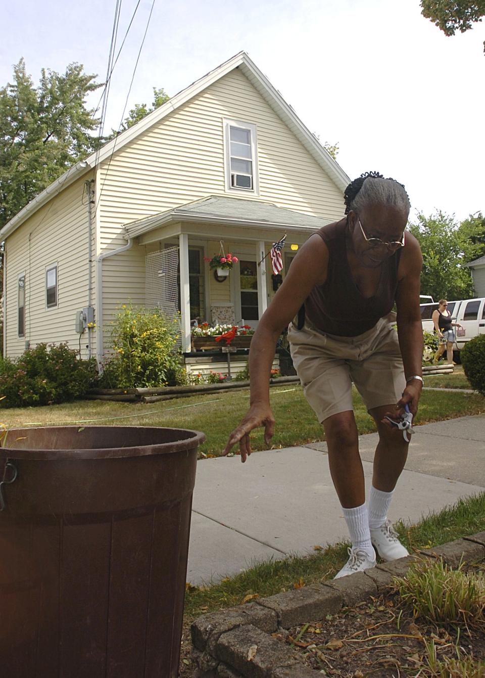 Hazel Bethea, close friend of Ruth Hallman and President of the Neighborhood Watch 120, does some yard work in front of the slain community activist's house Saturday. SHOOT DATE: 080407
PHOTO BY STAFF PHOTOGRAPHER ROBERT KILLIPS: