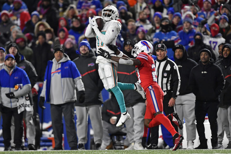 Miami Dolphins wide receiver Jaylen Waddle (17) makes a catch with Buffalo Bills cornerback Tre'Davious White (27) defending during the first half of an NFL football game in Orchard Park, N.Y., Saturday, Dec. 17, 2022. (AP Photo/Adrian Kraus)