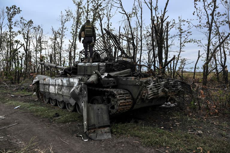 Un soldado ucraniano, sobre un tanque ruso abandonado en Izium. (Photo by Juan BARRETO / AFP)