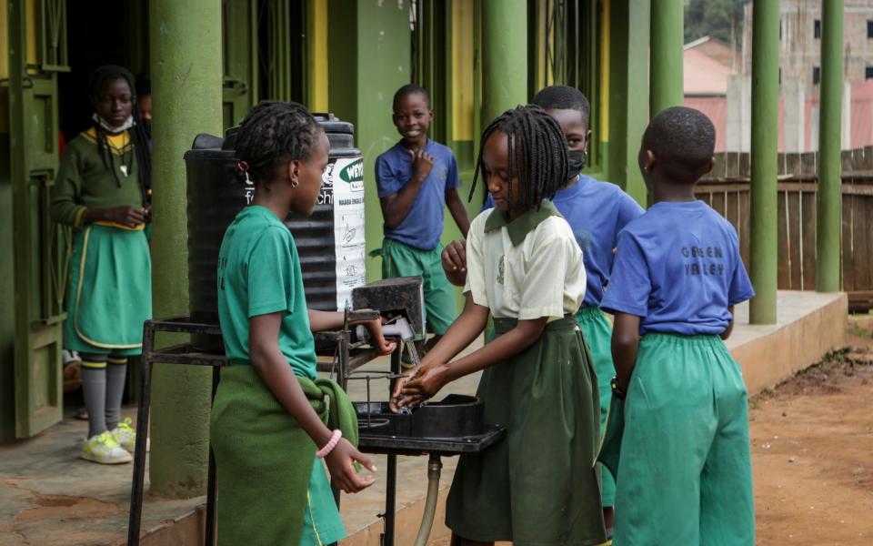 Pupils wash their hands before entering class at the Green Valley Primary School, one of three to report cases of Ebola in the capital, in Kampala - AP Photo/Hajarah Nalwadda
