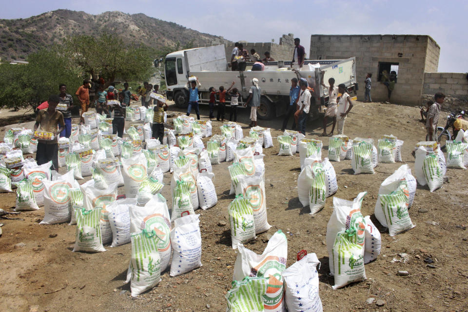 In this Sept. 23, 2018 file photo, men deliver aid donations from donors, in Aslam, Hajjah, Yemen. Houthi rebels in Yemen have blocked half of the United Nations’ aid delivery programs in the war-torn country — a strong-arm tactic to force the agency to give them greater control over the massive humanitarian campaign, along with a cut of billions of dollars in foreign assistance, according to aid officials and internal documents obtained by The Associated Press. (AP Photo/Hammadi Issa, File)