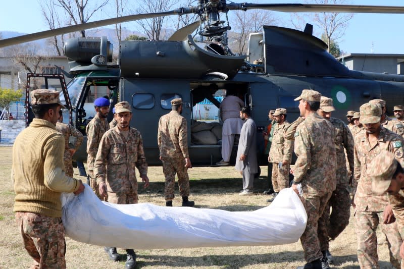 Pakistan Army soldiers load relief goods on a helicopter to distribute among people in affected areas after heavy snowfall and avalanches, in Muzaffarabad,