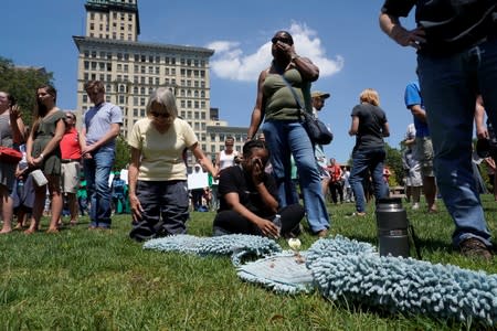 Mourners gather and pray during a vigil after a mass shooting in Dayton