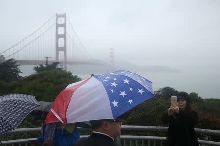 Tourists snap photographs at an overlook near the Golden Gate Bridge in San Francisco, California December 11, 2014. REUTERS/Robert Galbraith