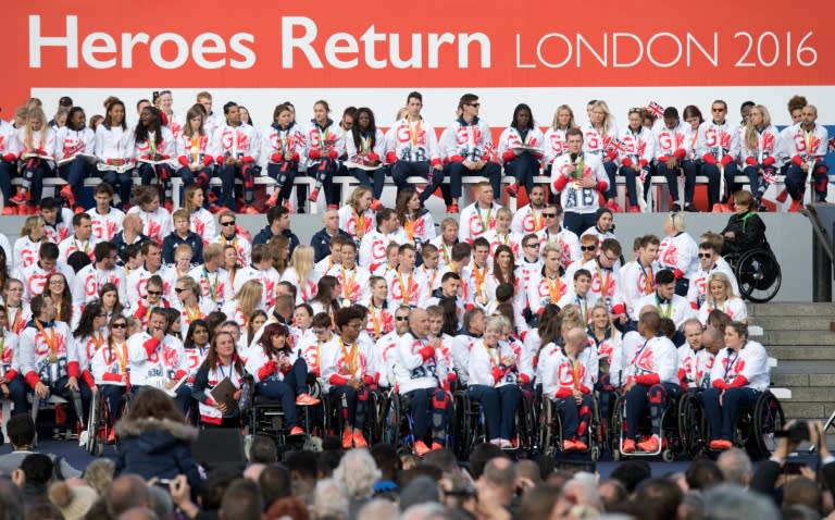 British gold medal-winning swimmer Adam Peaty (top R standing) speaks among other British athletes during the Olympics and Paralympics Team GB Rio 2016 Victory Parade in Trafalgar Square in London on October 18, 2016