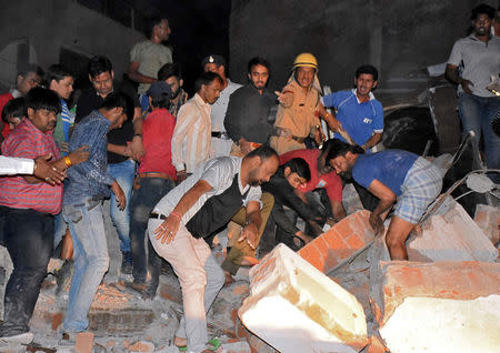 People remove the debris as they search for survivors at the site of a collapsed hotel building in Indore, India, March 31, 2018. Picture taken March 31, 2018. REUTERS/Stringer