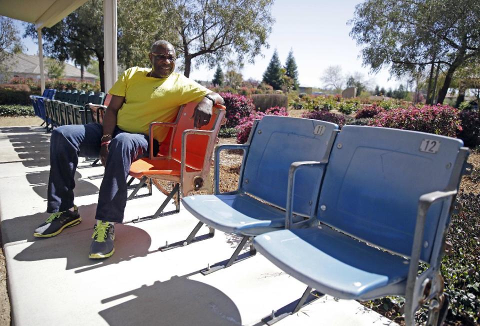 In this March 13, 2014 photo, Dusty Baker sits in a row of old seats from stadiums at all of his stops as a player by a batting cage at his home in Granite Bay, Calif. They're Nos. 11 and 12, since Baker wore 12 on his jersey. Out of uniform for the first time since taking 2007 off between managerial jobs with the Cubs and Reds, Baker is not slowing down much from his pressure-packed days in the dugout. (AP Photo/Eric Risberg)