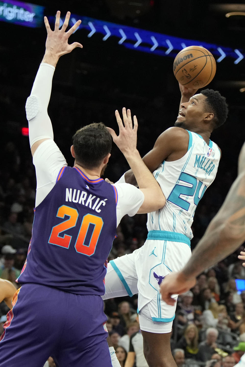 Charlotte Hornets forward Brandon Miller shoots over Phoenix Suns center Jusuf Nurkic (20) during the first half of an NBA basketball game, Friday, Dec. 29 2023, in Phoenix. (AP Photo/Rick Scuteri)