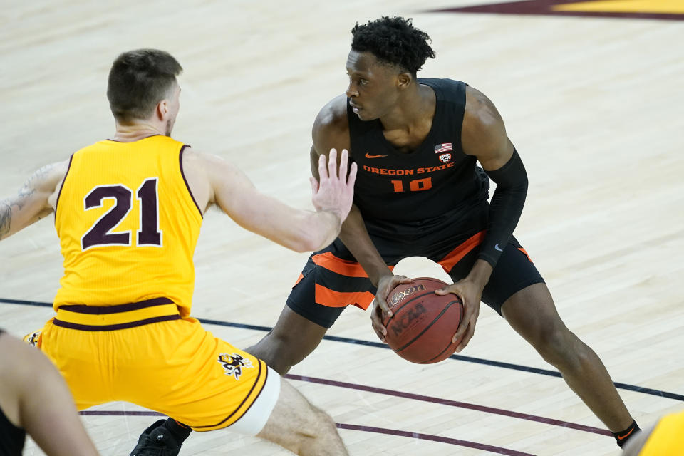 Oregon State forward Warith Alatishe (10) looks to pass as Arizona State forward Chris Osten (21) defends during the first half of an NCAA college basketball game, Sunday, Feb. 14, 2021, in Tempe, Ariz.(AP Photo/Matt York)