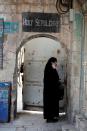 A woman in religious clothing speaks on her mobile phone next to an entrance to the Jerusalem's Church of the Holy Sepulchre amid coronavirus restrictions in the walled Old City