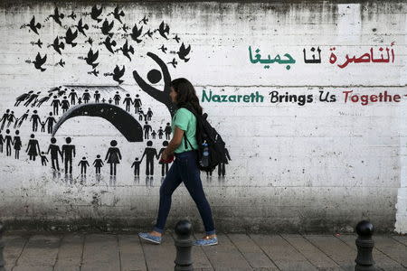 A youth walks past graffiti on a street in Nazareth, northern Israel October 12, 2015. REUTERS/Baz Ratner