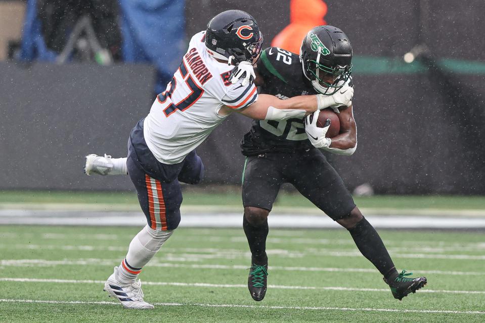 Nov 27, 2022; East Rutherford, New Jersey, USA; New York Jets running back Michael Carter (32) is tackled by Chicago Bears linebacker Jack Sanborn (57) during the first half at MetLife Stadium. Mandatory Credit: Vincent Carchietta-USA TODAY Sports