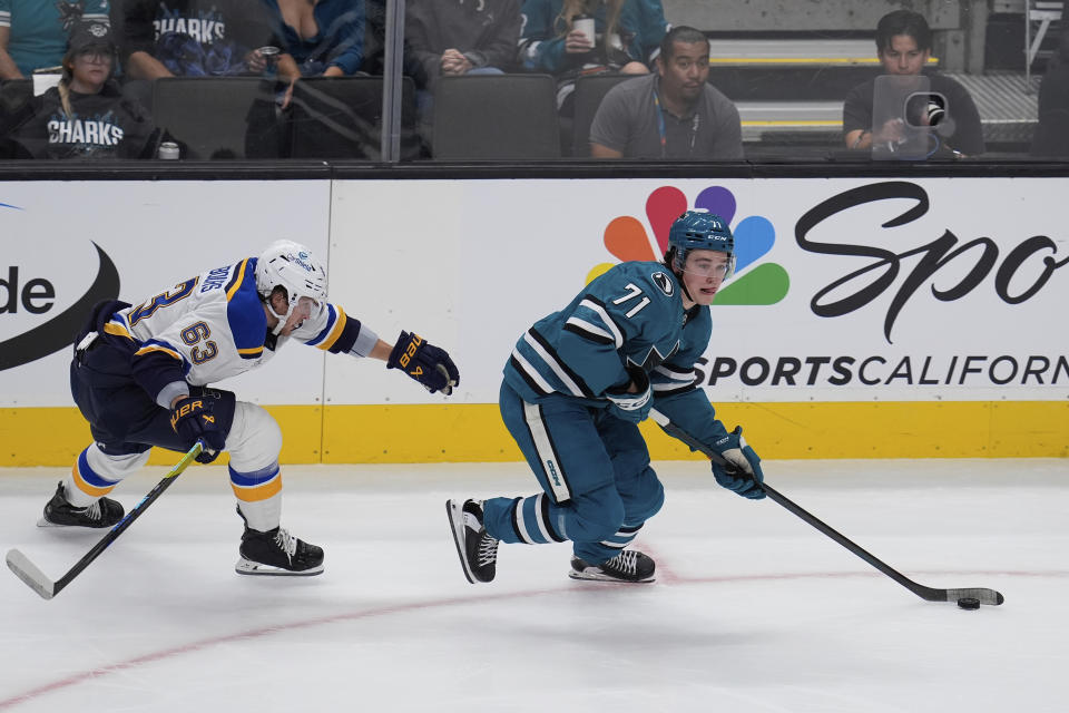 St. Louis Blues left wing Jake Neighbours, left, chases after San Jose Sharks center Macklin Celebrini, right, during the first period of an NHL hockey game Thursday, Oct. 10, 2024, in San Jose, Calif. (AP Photo/Godofredo A. Vásquez)