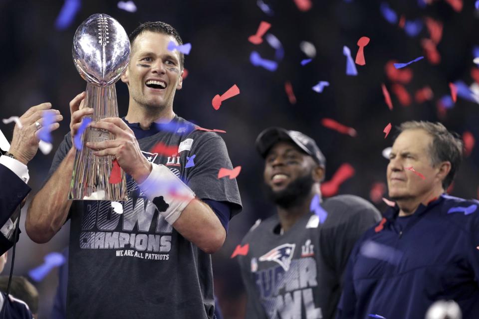 After Super Bowl LI, Patriots quarterback Tom Brady holds the Vince Lombardi Trophy beside coach Bill Belichick, right. (AP)