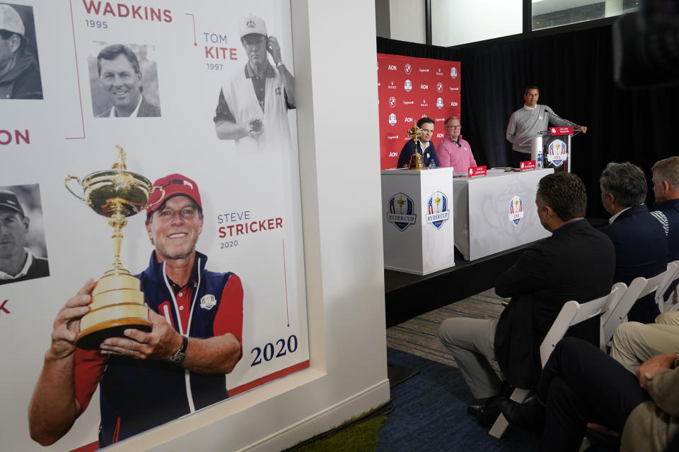 Zach Johnson, left, speaks after being named the 2023 United States Ryder Cup golf captain at PGA of America headquarters, Monday, Feb. 28, 2022, in Palm Beach Gardens, Fla. At center is Jim Richerson, president of the PGA of America, and right is Julius Mason, senior director of public awareness for the PGA. Displayed on the wall is Steve Stricker, former Ryder Cup captain. (AP Photo/Lynne Sladky)