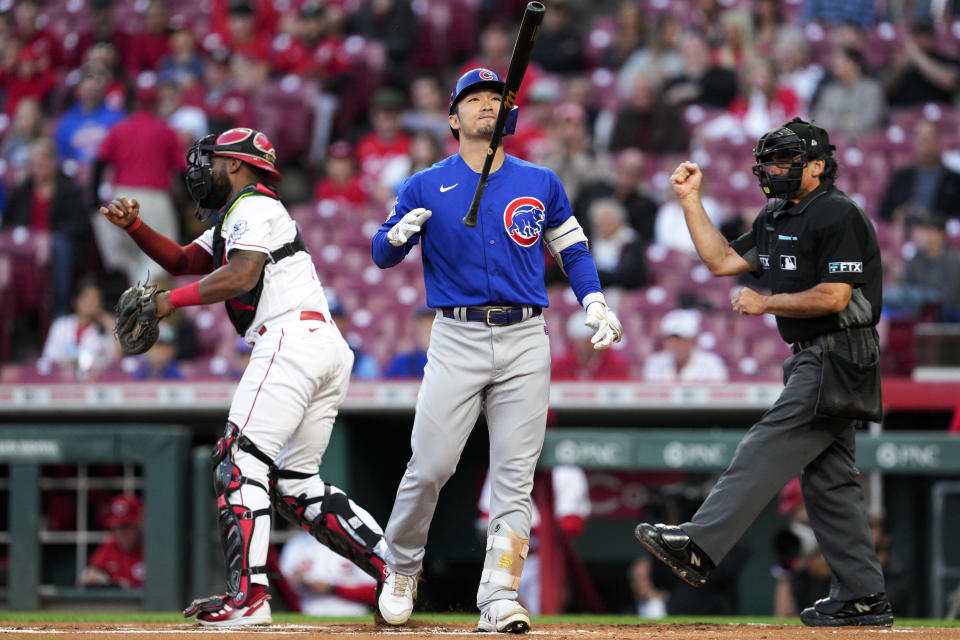 Chicago Cubs' Seiya Suzuki, center, reacts after being called out on strikes during the first inning of the team's baseball game against the Cincinnati Reds on Tuesday, Oct. 4, 2022, in Cincinnati. (AP Photo/Jeff Dean)