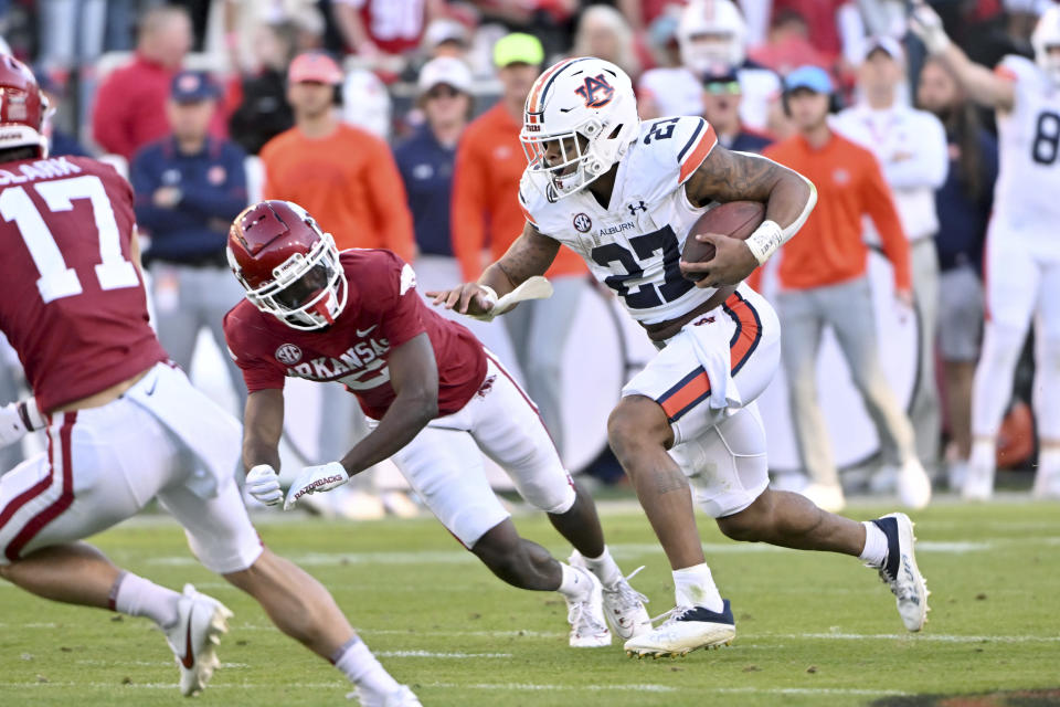 Auburn running back Jarquez Hunter (27) runs the ball past Arkansas defensive back Dwight McGlothern (2) during the second half of an NCAA college football game Saturday, Nov. 11, 2023, in Fayetteville, Ark. (AP Photo/Michael Woods)